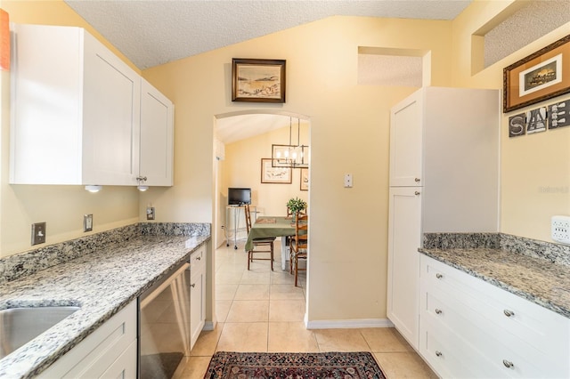 kitchen featuring white cabinetry, dishwasher, light stone countertops, and light tile patterned flooring