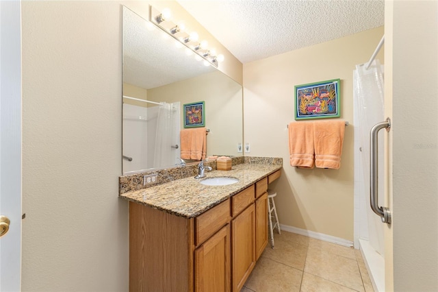 bathroom with walk in shower, tile patterned floors, a textured ceiling, and vanity