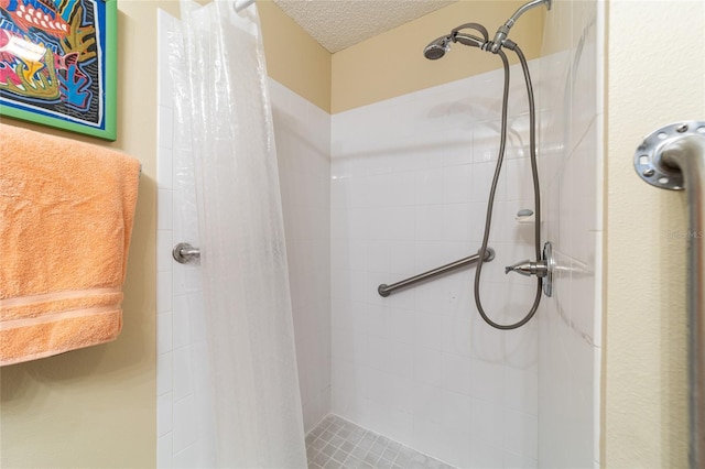 bathroom featuring a shower with shower curtain and a textured ceiling