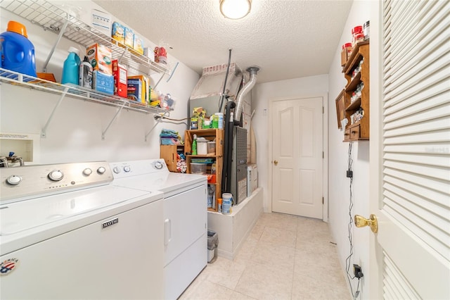 washroom featuring light tile patterned flooring, independent washer and dryer, and a textured ceiling