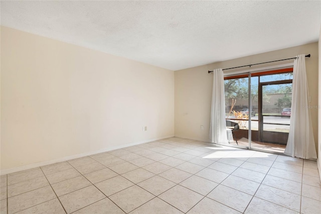 empty room featuring light tile patterned floors and a textured ceiling