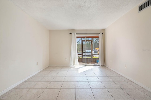 tiled spare room featuring a textured ceiling