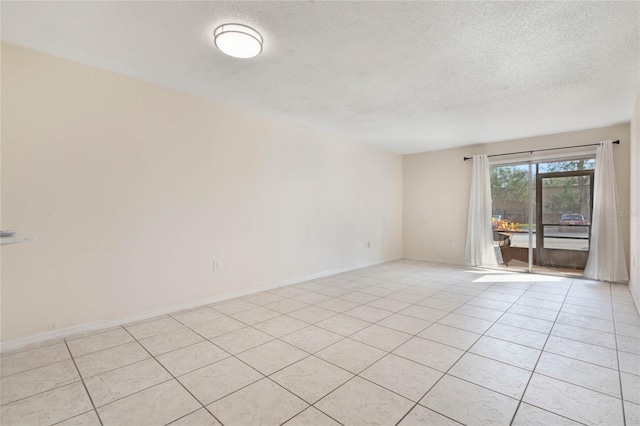 tiled spare room featuring a textured ceiling