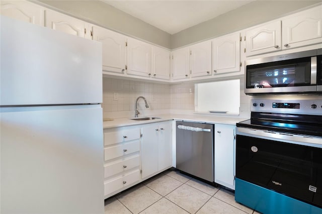 kitchen with sink, light tile patterned floors, appliances with stainless steel finishes, decorative backsplash, and white cabinets