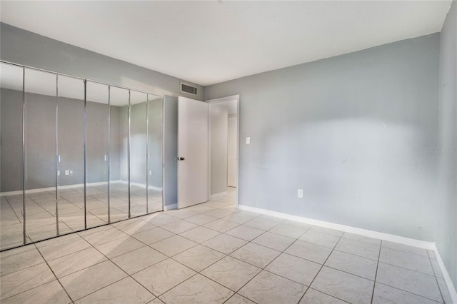 unfurnished bedroom featuring light tile patterned floors and a closet