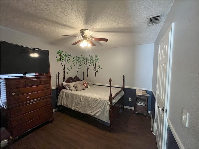 bedroom with ceiling fan, a textured ceiling, and dark hardwood / wood-style flooring