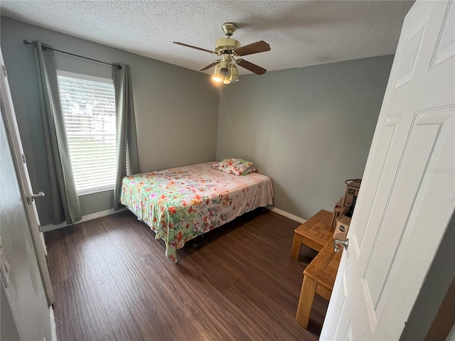 bedroom with ceiling fan, dark hardwood / wood-style floors, and a textured ceiling