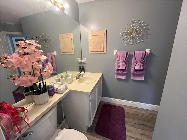 bathroom with hardwood / wood-style flooring, vanity, and toilet