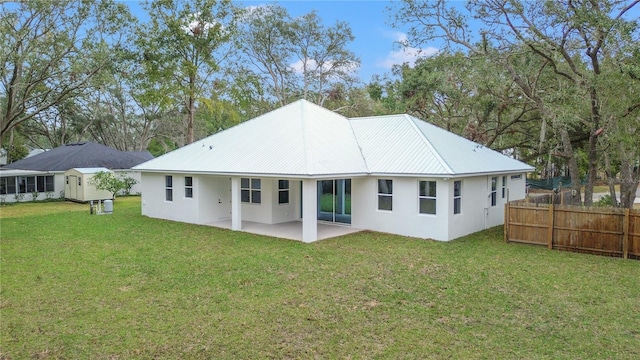 rear view of house with a patio area and a lawn