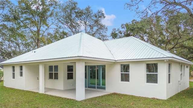 rear view of property with a yard and a patio area