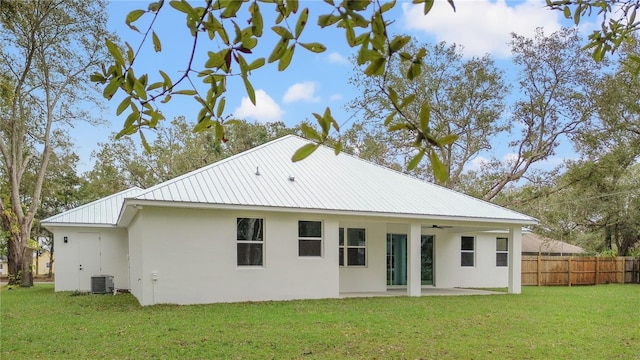 back of house featuring cooling unit, a yard, and a patio