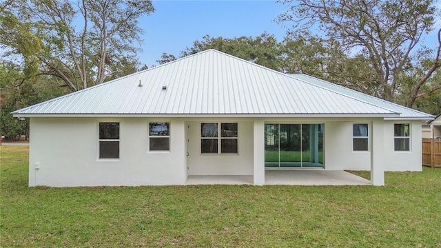 back of house featuring a lawn and a patio