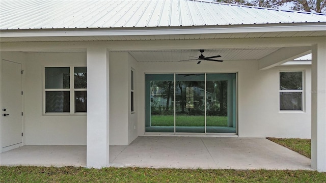 view of exterior entry featuring ceiling fan and a patio area