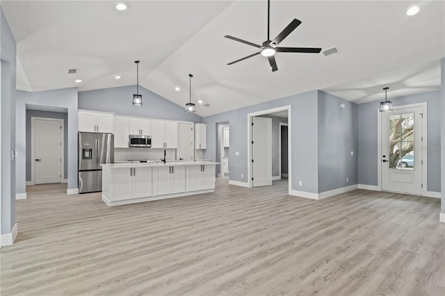 kitchen with white cabinetry, hanging light fixtures, light hardwood / wood-style flooring, an island with sink, and stainless steel appliances