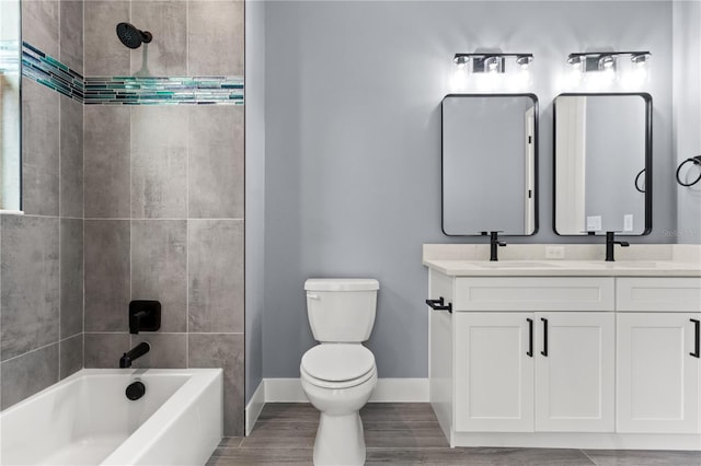 full bathroom featuring vanity, tiled shower / bath combo, toilet, and hardwood / wood-style flooring