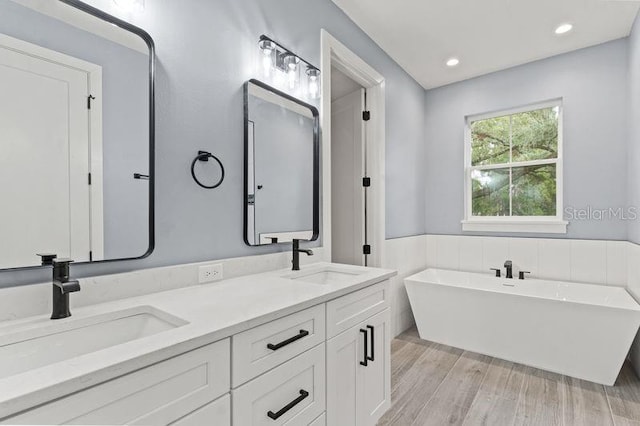 bathroom with vanity, a bathtub, and hardwood / wood-style flooring