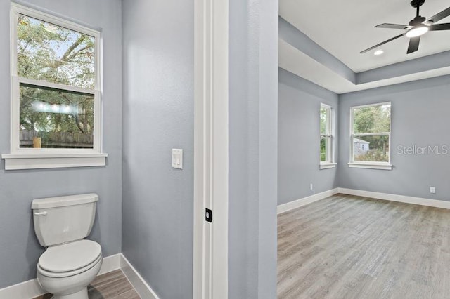 bathroom with hardwood / wood-style flooring, ceiling fan, and toilet