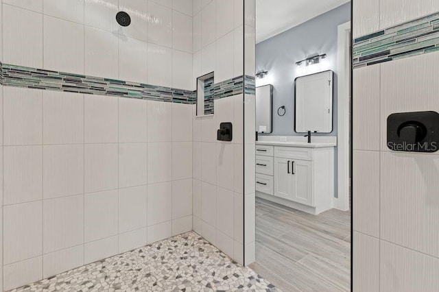 bathroom featuring tiled shower and vanity