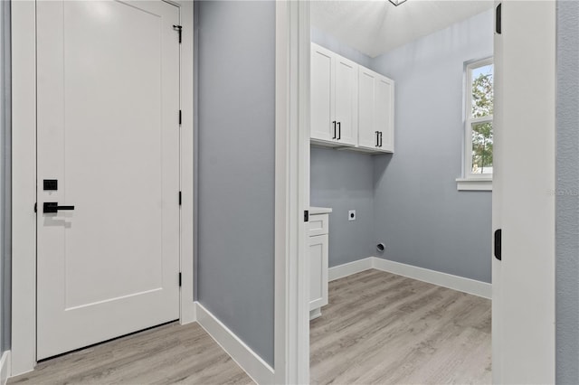 laundry room with cabinets, light hardwood / wood-style floors, and hookup for an electric dryer