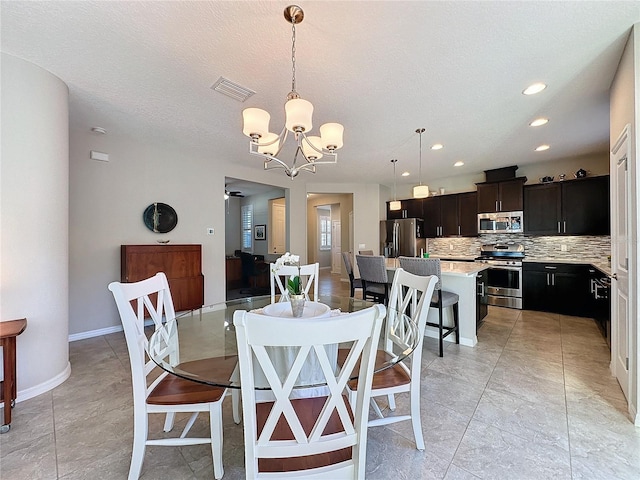 dining room with a textured ceiling and a notable chandelier