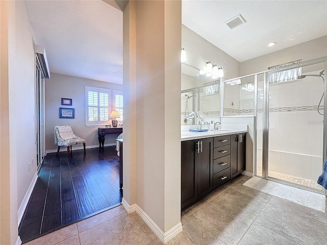 bathroom featuring tile patterned floors, vanity, and an enclosed shower