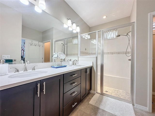 bathroom featuring a shower with shower door and vanity