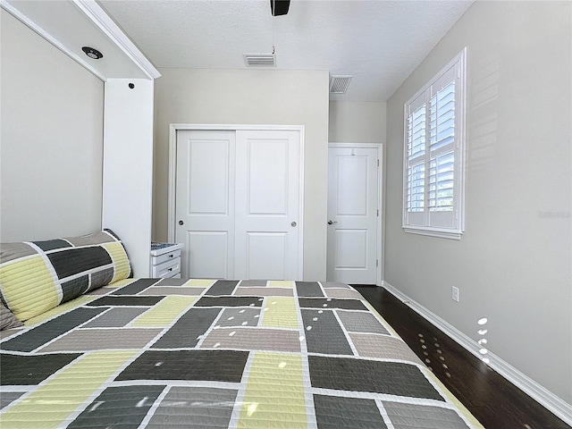 unfurnished bedroom featuring a closet, dark wood-type flooring, and a textured ceiling