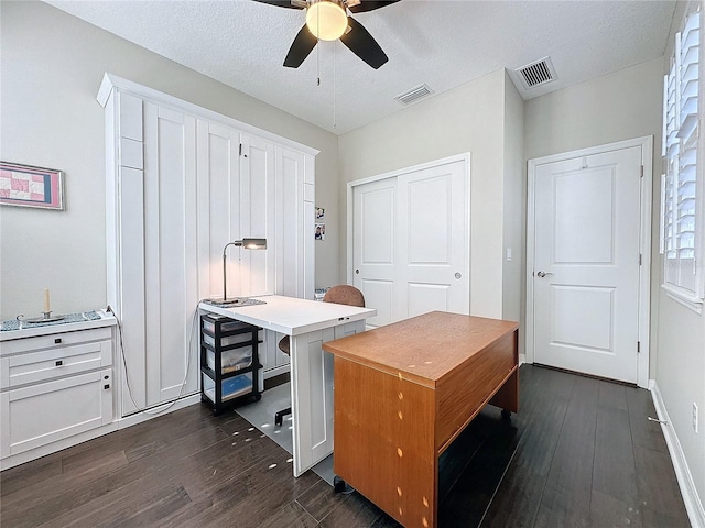 office area with ceiling fan, dark wood-type flooring, and a textured ceiling