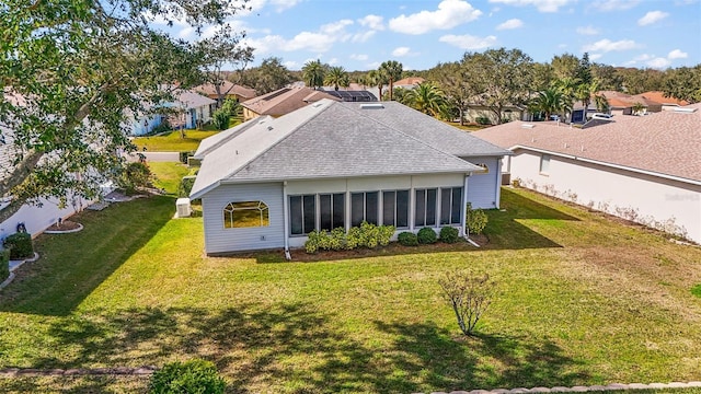 rear view of house with a sunroom and a lawn