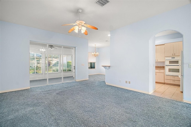 unfurnished living room with ceiling fan with notable chandelier and light carpet