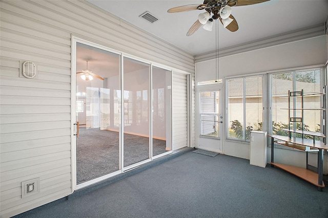 unfurnished sunroom featuring ceiling fan