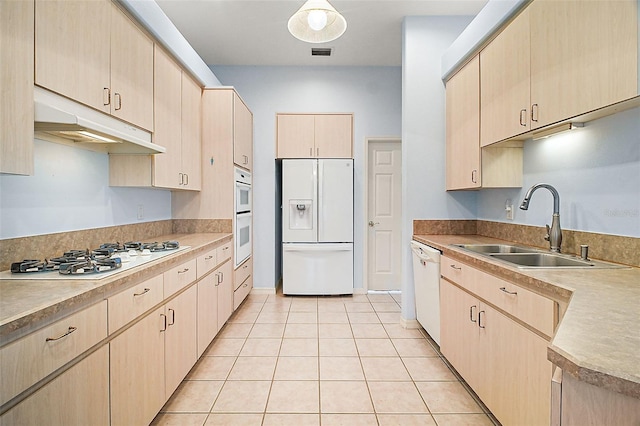 kitchen with sink, light brown cabinets, white appliances, and light tile patterned floors