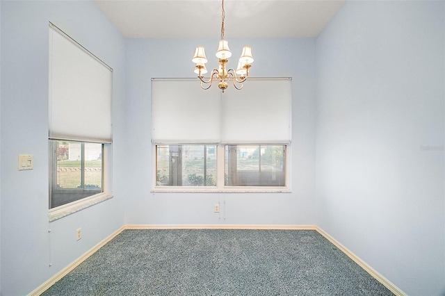 carpeted empty room with a chandelier