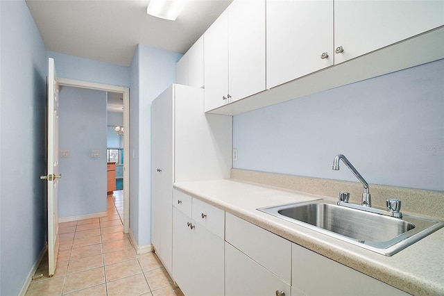 kitchen featuring white cabinetry, sink, and light tile patterned floors