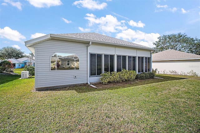 back of property featuring central AC and a lawn