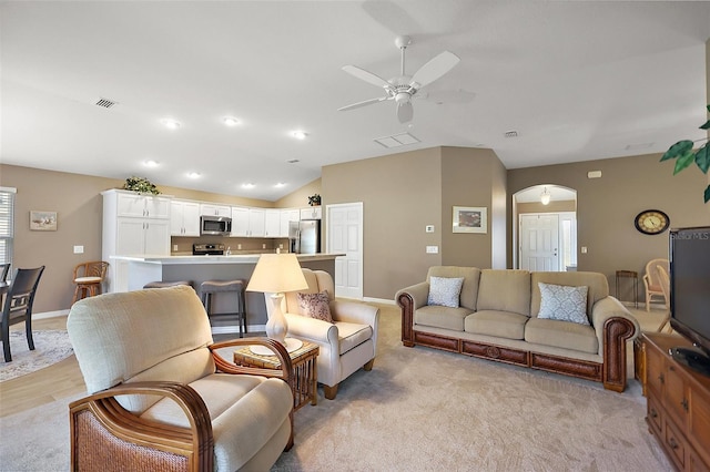 living room with light carpet, vaulted ceiling, and ceiling fan