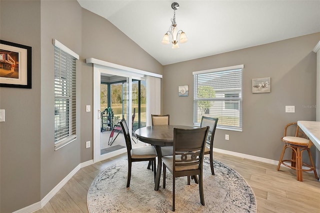 dining area with vaulted ceiling, a notable chandelier, and light hardwood / wood-style floors