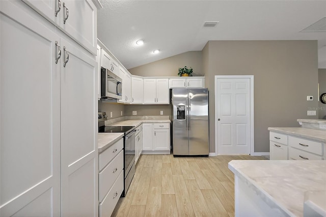 kitchen featuring lofted ceiling, white cabinets, light hardwood / wood-style floors, stainless steel appliances, and light stone countertops