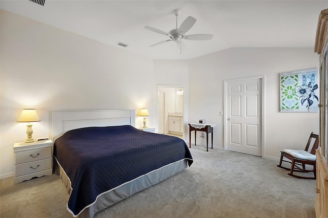 bedroom with vaulted ceiling, connected bathroom, light carpet, and ceiling fan