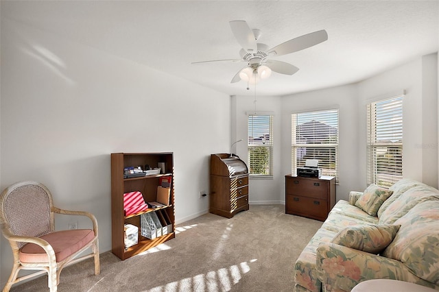 living area featuring light carpet, plenty of natural light, and ceiling fan