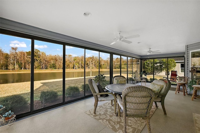 sunroom / solarium featuring a wealth of natural light, ceiling fan, and a water view