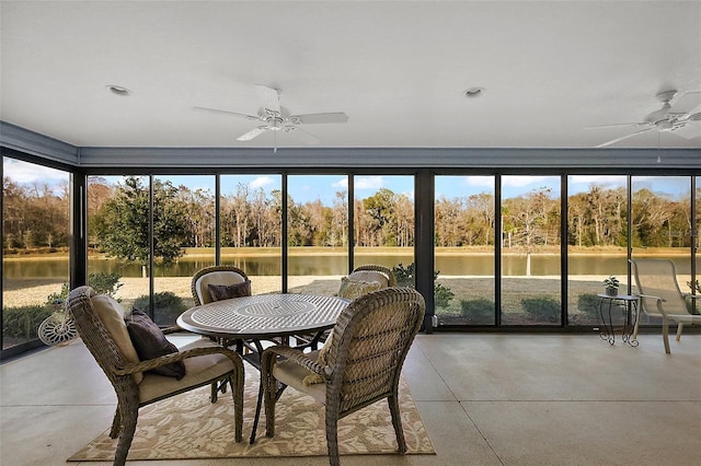 sunroom / solarium featuring a wealth of natural light, ceiling fan, and a water view