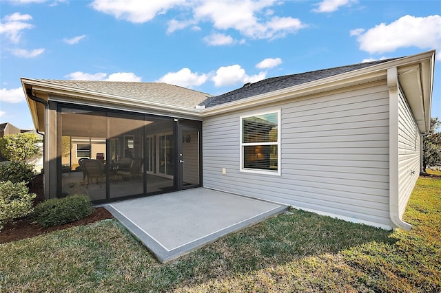 back of property featuring a patio, a sunroom, and a lawn