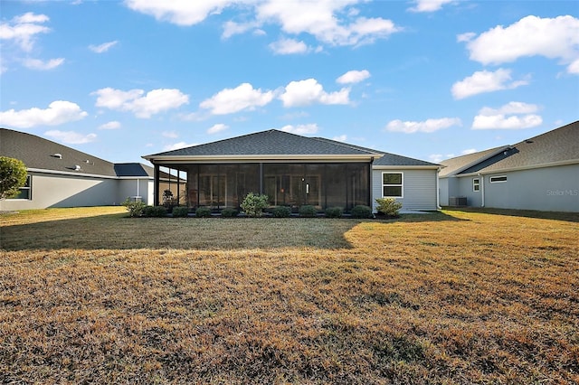 rear view of property with a sunroom, a yard, and central AC