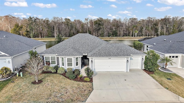 view of front of home with a garage, a water view, and a front lawn