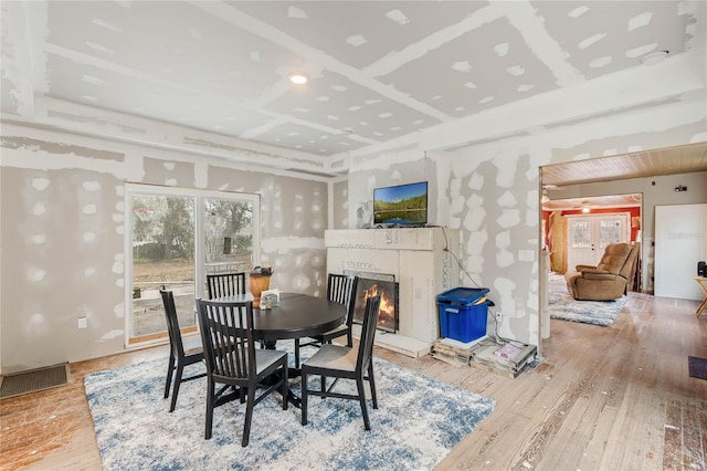 dining room with coffered ceiling and light wood-type flooring