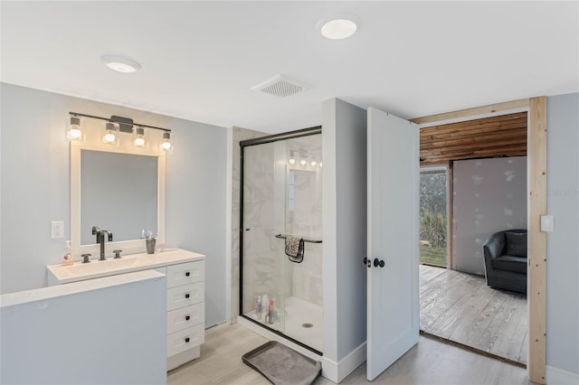 bathroom with vanity, an enclosed shower, and hardwood / wood-style floors