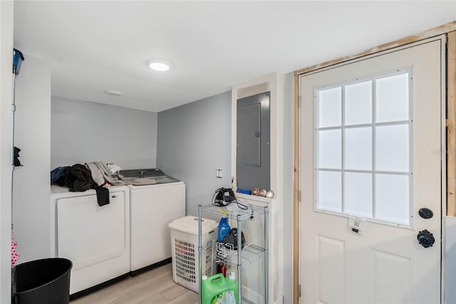 laundry area featuring separate washer and dryer, electric panel, and light wood-type flooring