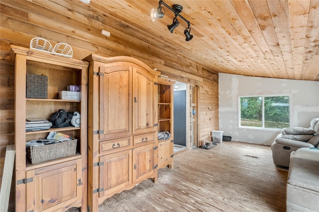 living room with lofted ceiling, wood ceiling, wooden walls, and light wood-type flooring