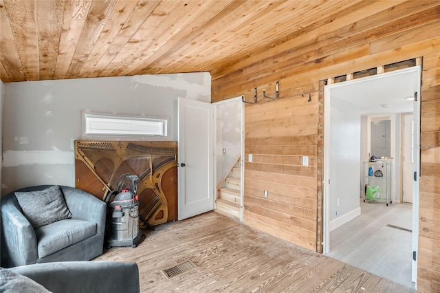 sitting room featuring wood walls, wooden ceiling, and light wood-type flooring